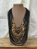 Collar multi negro con tubos dorados